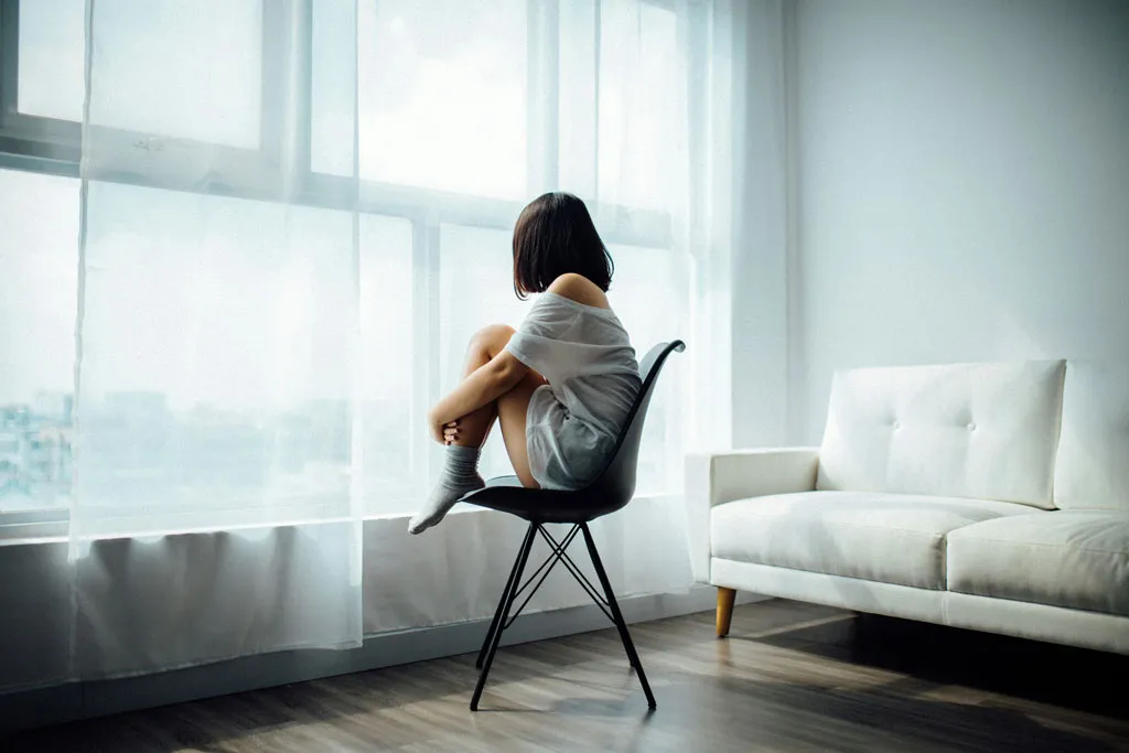 3 stages of relapse. A lady sitting on a chair looking out of the window