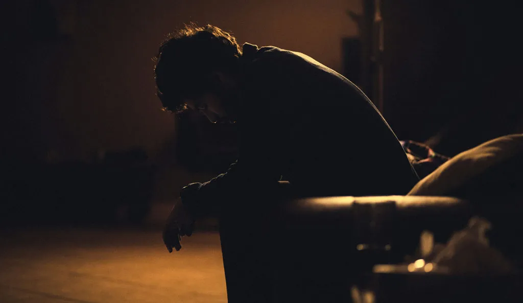 Understanding addiction. A man sitting in a chair feeling depressed in the dark