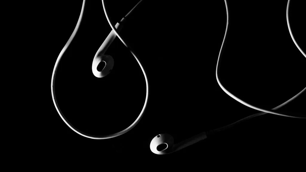 Music in addiction recovery - two earphones with a black background. The healing role of music in recovery